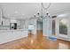 Open-concept kitchen and dining area with white cabinets, stainless appliances, and hardwood floors at 5413 Leopards Bane Ct, Holly Springs, NC 27540