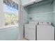 Laundry room featuring a window, washer, dryer, and wire shelving at 5413 Leopards Bane Ct, Holly Springs, NC 27540