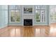 Bright living room featuring tall windows, a fireplace, and hardwood floors at 5413 Leopards Bane Ct, Holly Springs, NC 27540