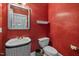 Unique powder room featuring red floral wallpaper, a decorative mirror and a patterned sink at 5413 Leopards Bane Ct, Holly Springs, NC 27540