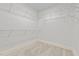 Empty walk-in closet features neutral carpet, base trim and rows of wire shelving at 5413 Leopards Bane Ct, Holly Springs, NC 27540
