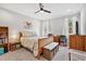 Bright bedroom with a wooden bed frame, floral bedding, ceiling fan, and lots of storage at 561 Circle Dr, Angier, NC 27501