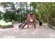 Fun community playground with slides and climbing structures nestled amongst mature trees and natural landscaping at 5815 Windham Dr, Raleigh, NC 27609