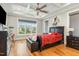 Spacious bedroom with tray ceilings, a large window, and beautiful hardwood floors at 5820 Brayton Park Pl, Holly Springs, NC 27540