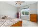 Comfortable bedroom with a ceiling fan, bright window, carpeted floors, and standard closet for storage at 5820 Brayton Park Pl, Holly Springs, NC 27540