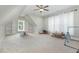Spacious bonus room with built-in shelving, ceiling fan, and neutral carpet at 5820 Brayton Park Pl, Holly Springs, NC 27540