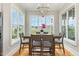 Dining room features a large window, hardwood floors, and modern chandelier at 5820 Brayton Park Pl, Holly Springs, NC 27540