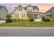 Charming two-story home with manicured lawn and inviting front porch with the sky at sunset at 5820 Brayton Park Pl, Holly Springs, NC 27540