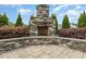 Custom outdoor stone fireplace with patio, ideal for entertaining and relaxation at 5820 Brayton Park Pl, Holly Springs, NC 27540