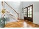 Bright foyer with hardwood floors, staircase, board and batten walls, and double doors at 5820 Brayton Park Pl, Holly Springs, NC 27540