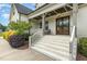 Inviting front porch with brick stairs, white railing, and stained double doors at 5820 Brayton Park Pl, Holly Springs, NC 27540