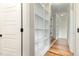 Bright hallway features hardwood floors, white trim and door, and built-in shelving for storage and decor at 5820 Brayton Park Pl, Holly Springs, NC 27540