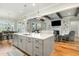 Open kitchen and living area, featuring a large center island, stainless appliances, and hardwood floors at 5820 Brayton Park Pl, Holly Springs, NC 27540