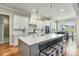 Bright, modern kitchen features a large island, white cabinetry, stainless steel appliances, and pendant lighting at 5820 Brayton Park Pl, Holly Springs, NC 27540