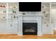 Cozy living room with a fireplace, built-in shelving, and hardwood floors at 5820 Brayton Park Pl, Holly Springs, NC 27540