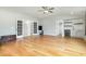 Spacious living room featuring hardwood floors, a ceiling fan, and bar area with shelving and a mini-fridge at 5820 Brayton Park Pl, Holly Springs, NC 27540