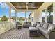 Relaxing screened porch with ample seating, wood floors, and outdoor ceiling fans at 5820 Brayton Park Pl, Holly Springs, NC 27540