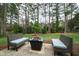 Cozy backyard setting with outdoor seating around a fire pit and mature trees at 5920 North Hills Dr, Raleigh, NC 27609