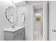 Charming bathroom featuring modern fixtures, a decorative mirror, and gray cabinets at 5920 North Hills Dr, Raleigh, NC 27609