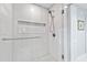 Modern bathroom shower with sleek, white tiled walls and a rain shower head at 5920 North Hills Dr, Raleigh, NC 27609