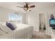 Bright bedroom featuring a ceiling fan, large window, and ensuite bathroom for added convenience at 63 Radcliffe Ct, Clayton, NC 27527