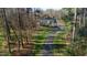 Aerial view of a home surrounded by trees with a long driveway in a natural setting at 65 Gentle Winds Dr, Chapel Hill, NC 27517