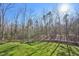 Picturesque backyard featuring lush green grass and beautiful surrounding woods offers privacy at 65 Gentle Winds Dr, Chapel Hill, NC 27517