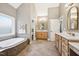 Spacious bathroom featuring a soaking tub, double vanities, and ample counter space at 65 Gentle Winds Dr, Chapel Hill, NC 27517