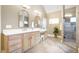 Bright bathroom with a double vanity, decorative mirrors, walk-in shower, and tiled floors at 65 Gentle Winds Dr, Chapel Hill, NC 27517
