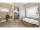 Bright bathroom featuring a shower, soaking tub, and large window for natural light at 65 Gentle Winds Dr, Chapel Hill, NC 27517