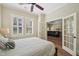 Bedroom with shuttered windows, light walls, and glass doors that open to the living room at 65 Gentle Winds Dr, Chapel Hill, NC 27517