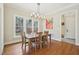 Bright dining room boasts wood floors, large windows, and an elegant chandelier above the dining table at 65 Gentle Winds Dr, Chapel Hill, NC 27517