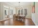 Dining room featuring hardwood floors, a modern chandelier, and views into a sunroom at 65 Gentle Winds Dr, Chapel Hill, NC 27517