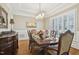 Formal dining room with hardwood floors, coffered ceilings, and large window with plantation shutters at 65 Gentle Winds Dr, Chapel Hill, NC 27517