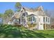 Angled rear view of the home showcasing the deck, lawn, and landscaping at 65 Gentle Winds Dr, Chapel Hill, NC 27517