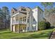 Exterior of home with deck, patio, and lush green lawn at 65 Gentle Winds Dr, Chapel Hill, NC 27517