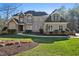 Beautiful two-story brick home with manicured lawn and a mix of stone and wood facade accents at 65 Gentle Winds Dr, Chapel Hill, NC 27517