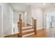 Hallway featuring hardwood floors, elegant railings, and natural light at 65 Gentle Winds Dr, Chapel Hill, NC 27517