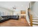 Spacious living room with a large sectional couch, bar area, wood floors, and staircase at 65 Gentle Winds Dr, Chapel Hill, NC 27517