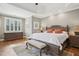 Main bedroom with detailed tray ceiling, hardwood floors, and a decorative rug at 65 Gentle Winds Dr, Chapel Hill, NC 27517