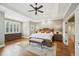 Main bedroom featuring hardwood floors, tray ceiling, and large windows at 65 Gentle Winds Dr, Chapel Hill, NC 27517