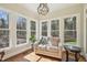 Sunroom filled with natural light, featuring hardwood floors and a comfortable sitting area at 65 Gentle Winds Dr, Chapel Hill, NC 27517