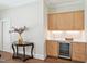Wet bar featuring light wood cabinets, white countertop, sink, wine fridge, and decorative flowers at 65 Gentle Winds Dr, Chapel Hill, NC 27517