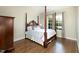 Bedroom with wooden floors, four poster bed and windows for natural light at 7004 Bartons Bend Way, Raleigh, NC 27614