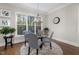 Bright dining area boasts a glass table, seating for four, and scenic outdoor views at 7004 Bartons Bend Way, Raleigh, NC 27614