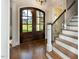 Light-filled foyer with dark wood floors, staircase, and grand double doors at 7004 Bartons Bend Way, Raleigh, NC 27614