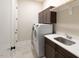 The laundry room offers modern appliances, tile floors and ample storage at 7004 Bartons Bend Way, Raleigh, NC 27614