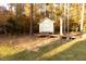 Backyard shed with wooden deck platform among trees providing private outdoor storage at 7004 Bartons Bend Way, Raleigh, NC 27614