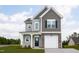 Inviting two-story home with stone accents, a charming front porch, and an attached garage offers modern living and curb appeal at 71 Furley St, Homesite 116, Sanford, NC 27330