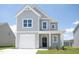 Beautiful two-story home with grey siding, a well-manicured lawn, and an attached garage offers a blend of comfort and style at 71 Furley St, Homesite 116, Sanford, NC 27330